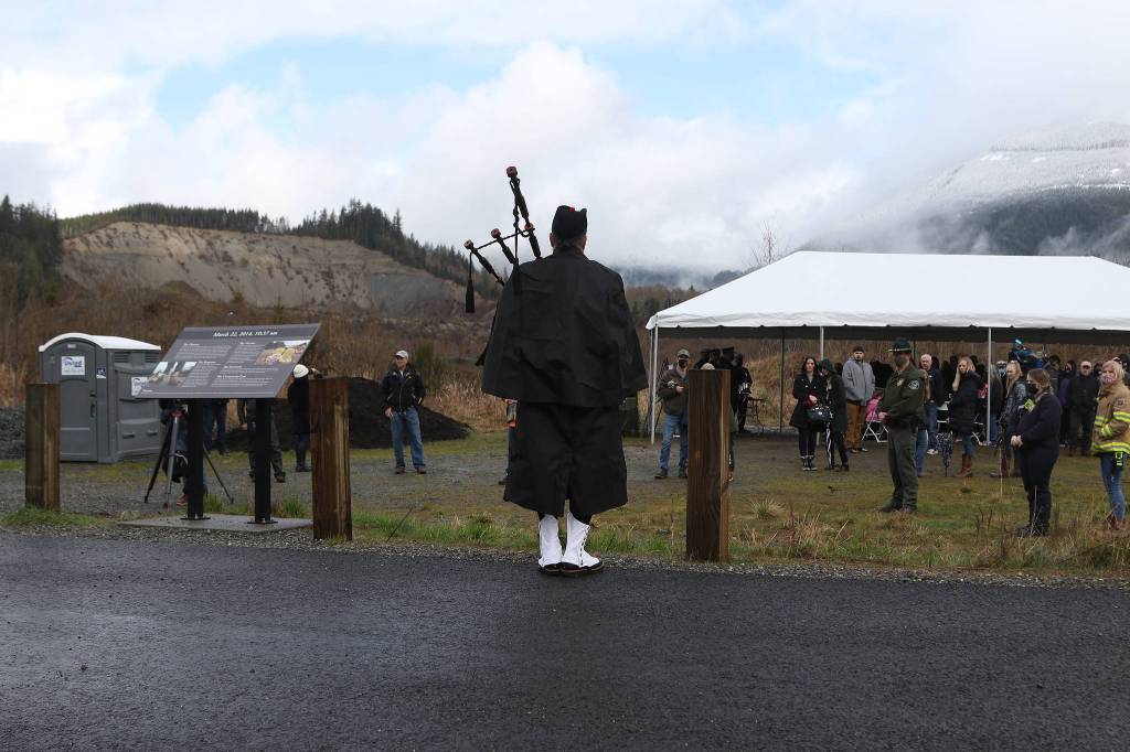 A bagpiper plays Amazing Grace at the end of a memorial ceremony marking the seventh anniversary of the Oso mudslide on Monday near Oso. (Andy Bronson / The Herald)
