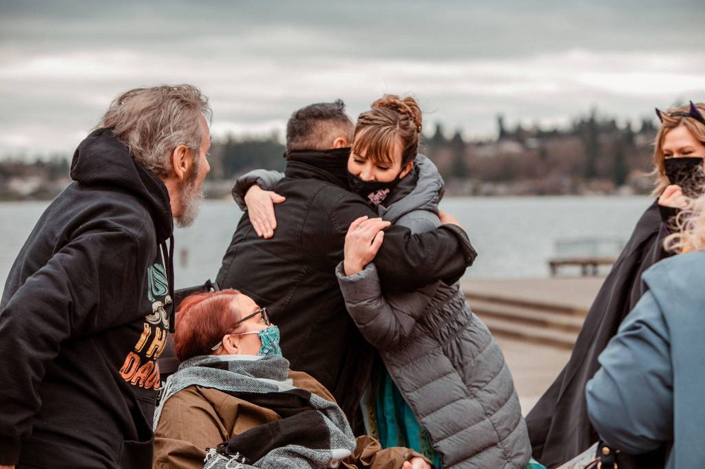Jon Erickson (center left) and Karin Reed embrace during a fundraiser at Lundeen Park in Lake Stevens on March 6. (Stephanie Walls)