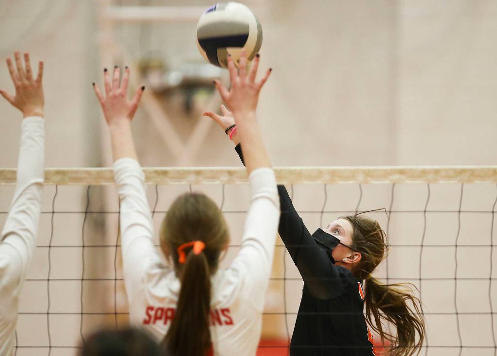 Monroes River Mahler sends the ball over two Stanwood defenders as Stanwood took on Monroe in a volleyball game on Wednesday, March 17, 2021 in Stanwood, Washington. (Andy Bronson / The Herald)
