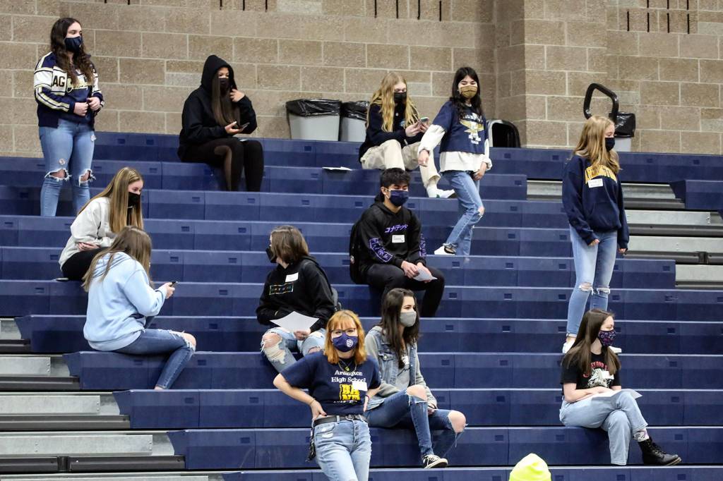 Students await the start of an assembly Friday morning at Arlington High School. (Kevin Clark / The Herald)
