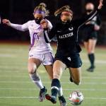 Lake Stevens Zoie Hopkins (left) and Jacksons Abigail McKay vie for control of the ball Thursday night at Memorial Stadium in Everett on March 18, 2021. (Kevin Clark / The Herald)