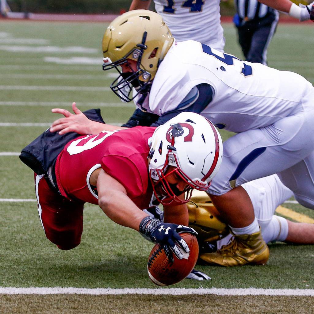 Cascades Julian Thomas dives under Everetts Tanner Beard for a touchdown at Everett Memorial Stadium Friday night on March 19, 2021. (Kevin Clark / The Herald)
Cascades Julian Thomas dives under Everetts Tanner Beard for a touchdown at Everett Memorial Stadium Friday night on March 19, 2021. (Kevin Clark / The Herald)
