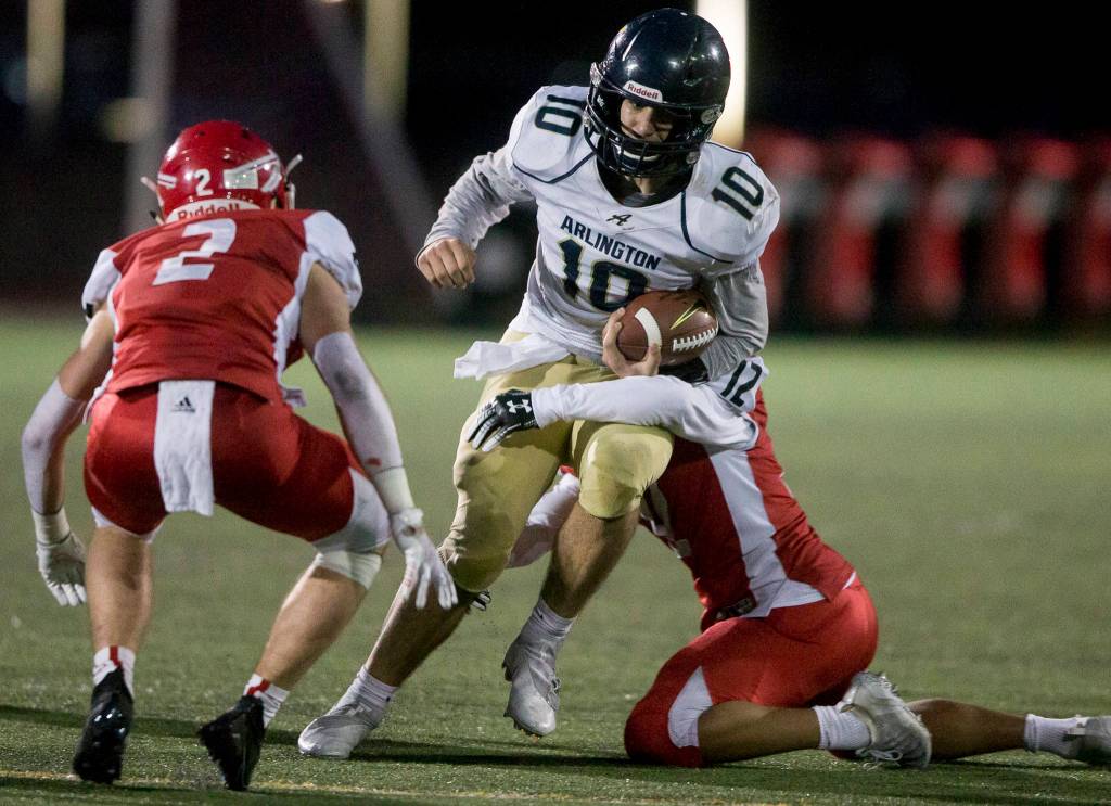 Arlingtons Michael Tsoukalas is tackled during the game on Friday, March 19, 2021 in Marysville, Wa. (Olivia Vanni / The Herald)
