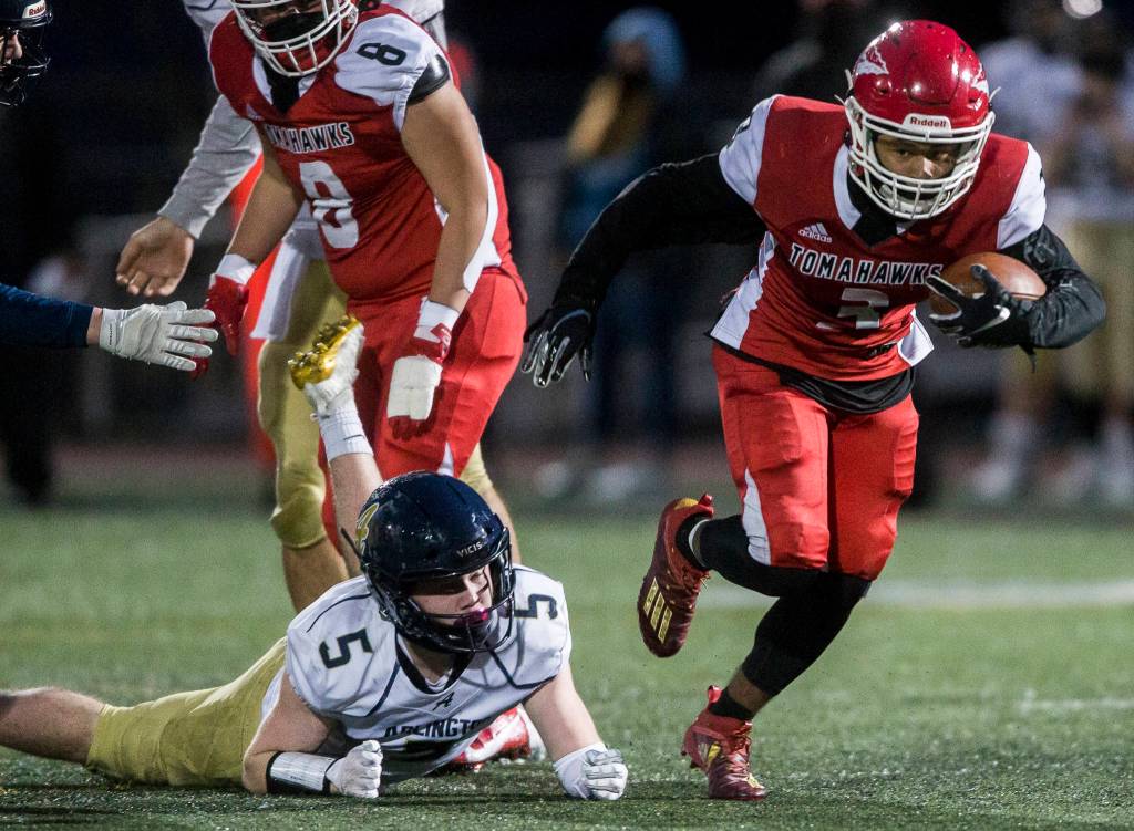 Marysville-Pilchucks Gaylen Gray escapes a tackle by Arlingtons Luke Brown during the game on Friday, March 19, 2021 in Marysville, Wa. (Olivia Vanni / The Herald)