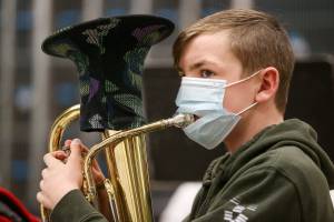 Shaun Metz wears a mask with a slit in it so he can play the baritone during Haller Middle School band practice on Thursday, March 25, 2021 in Arlington, Washington.  (Andy Bronson / The Herald)