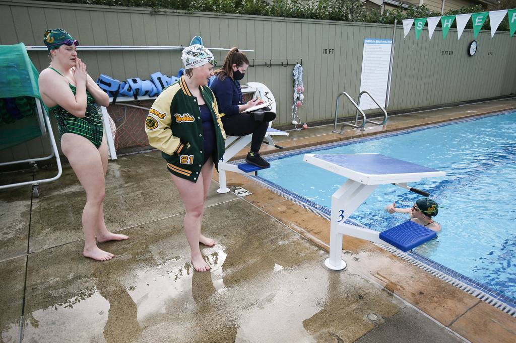 Madeleine Stole (in the pool) gives a thumbs up after finishing her race as the Shorecrest girls swim team practices at a four-lane outdoor pool at Sheridan Beach Community Club on Tuesday in Lake Forest Park. (Andy Bronson / The Herald)