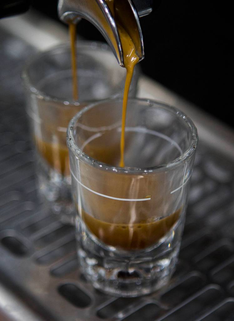 Shots of coffee fill up from a Synesso Seattle-built espresso machine Thursday at Milk House Coffee Co. in Everett. (Olivia Vanni / The Herald)