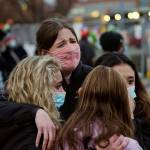 Sophia Kennedy (top), Kaylynn Devivo (left), Nirbisha Shetsha (bottom) and Josie Elowsky comfort each other along a fence put up around the parking lot where a mass shooting took place in a King Soopers grocery store a day earlier, March 23, 2021, in Boulder, Colo. (David Zalubowski / Associated Press)