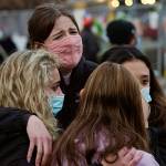 Clockwise from back center, Sophia Kennedy, Kaylynn Devivo, Nirbisha Shetsha and Josie Elowsky comfort each other along a fence put up around the parking lot where a mass shooting took place in a King Soopers grocery store a day earlier, Tuesday, March 23, 2021, in Boulder, Colo. (AP Photo/David Zalubowski)