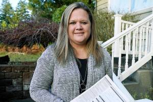 Rep. Tarra Simmons holds blank voter registration forms as she poses for a photo Wednesday, Dec. 9, 2020, at her home in Bremerton. Simmons is believed to be the first formerly incarcerated person to win election to the Statehouse. (AP Photo/Ted S. Warren, file)
