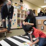 Washington State Governor Jay Inslee speaks with special ed Pre-K teacher Michelle Ling in her classroom at Phantom Lake Elementary School in Bellevue, Wash. Tuesday, March 2, 2021. (Ellen M. Banner/The Seattle Times via AP, Pool)