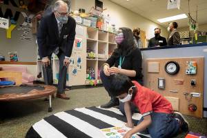 Washington State Governor Jay Inslee speaks with special ed Pre-K teacher Michelle Ling in her classroom at Phantom Lake Elementary School in Bellevue, Wash. Tuesday, March 2, 2021. (Ellen M. Banner/The Seattle Times via AP, Pool)