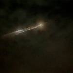 In this image taken from video, debris from a SpaceX rocket lights up the sky behind clouds over Vancouver, Washington, on Thursday evening. (Roman Puzhlyakov via AP)
