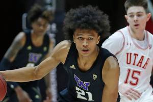 Washington forward RaeQuan Battle (21) brings the ball up court as Utah guard Rylan Jones (15) defends in the first half during an NCAA college basketball game Thursday, Jan. 23, 2020, in Salt Lake City. (AP Photo/Rick Bowmer)