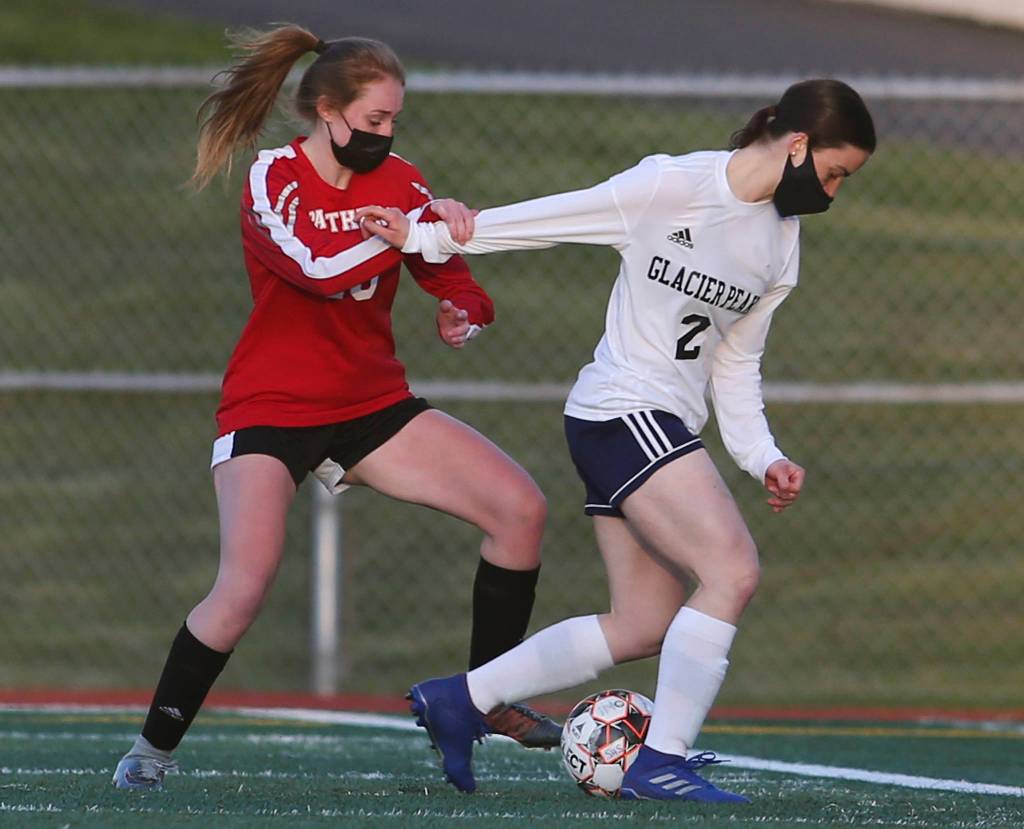 Snohomishs Emma English tries to hold back Glacier Peaks Greta Henrie during a girls soccer match at Veterans Memorial Stadium on Monday in Snohomish. (Andy Bronson / The Herald)