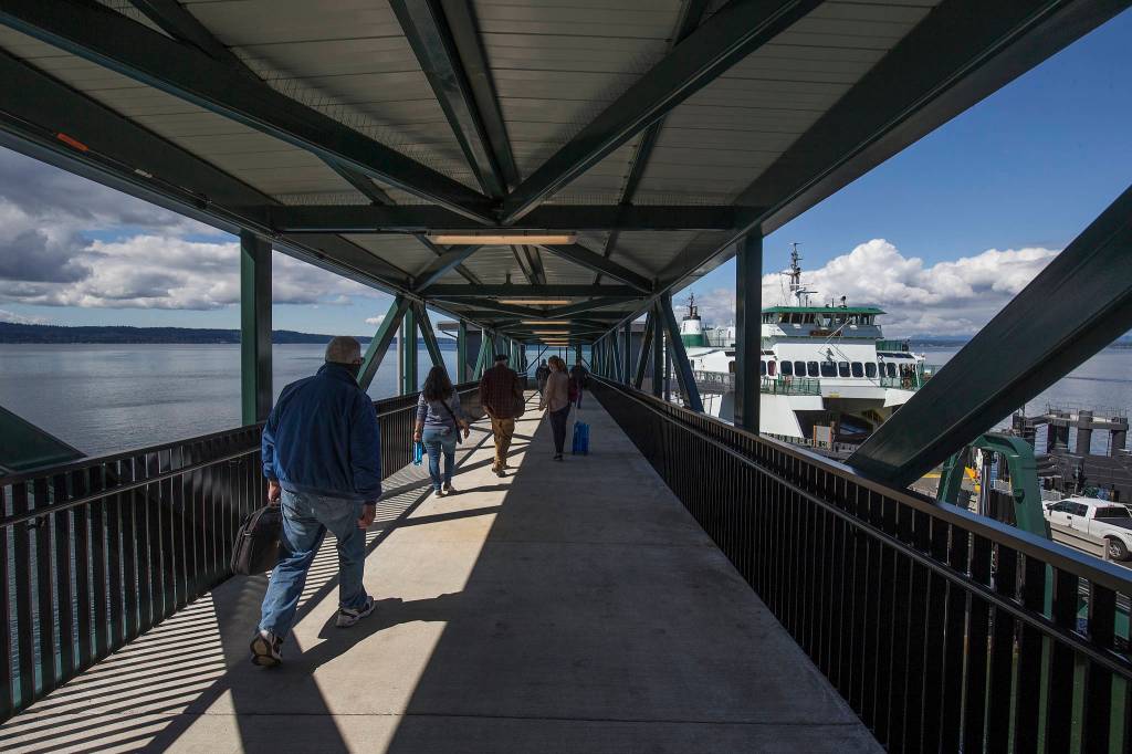 A walk-on passenger uses the overhead walkway to board a ferry at the Mukilteo ferry terminal on Monday. (Andy Bronson / The Herald)