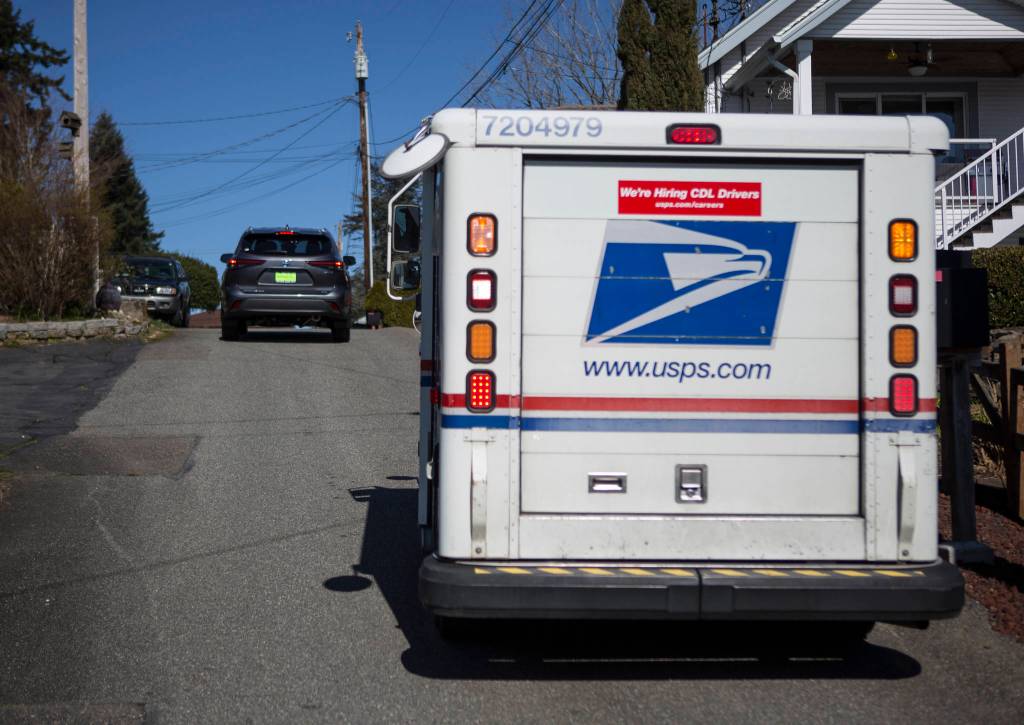 Two cars navigate narrow West Ibberson Drive on March 10 in Everett. The city had proposed to put a pedestrian trail along the road but removed the segment after neighbors criticized the route. (Olivia Vanni / The Herald)