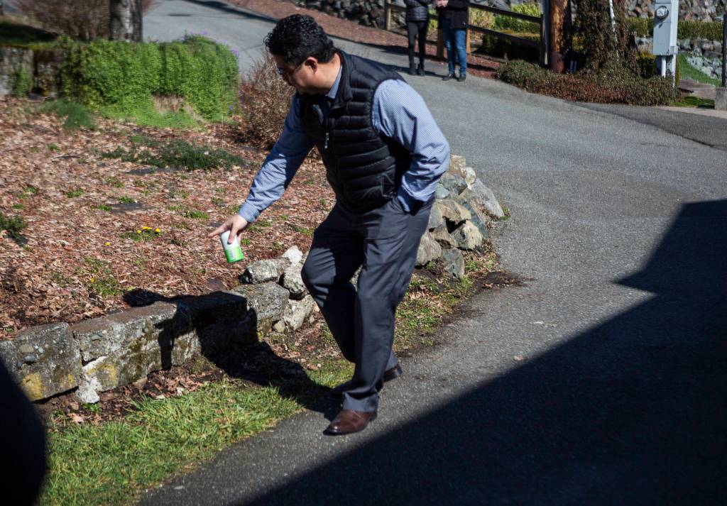 A neighbor talks March 10 about having to rebuild a rock wall consistently because of vehicles not being able to make the turn on West Ibberson Drive in Everett. The City of Everett scrapped designs to put a pedestrian trail on the road after neighbors opposed it. (Olivia Vanni / The Herald)
