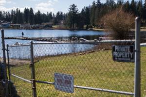 A person fishes off a dock at Thornton A. Sullivan Park that boarders the private because along West Ibberson Drive on Wednesday, March 10, 2021 in Everett, Wa. (Olivia Vanni / The Herald)