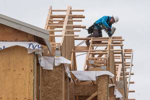 A construction worker works on the roof line of  apartments under construction in the 1600 block of E. Marine View Drive on Friday, April 24, 2020 in Everett, Wa. (Andy Bronson / The Herald)