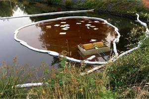 Absorbents placed to contain oil in the stormwater pond outside Achilles USA, July 2018. (Washington State Department of Ecology)