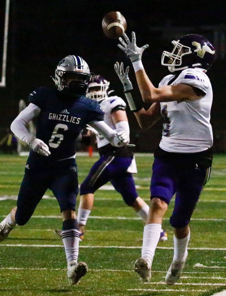 Lake Stevens Gabe Ramsey makes a reception with Glacier Peaks Jackson Hawkins trailing Thursday night at Veterans Memorial Stadium in Snohomish on April 1, 2021. (Kevin Clark / The Herald)