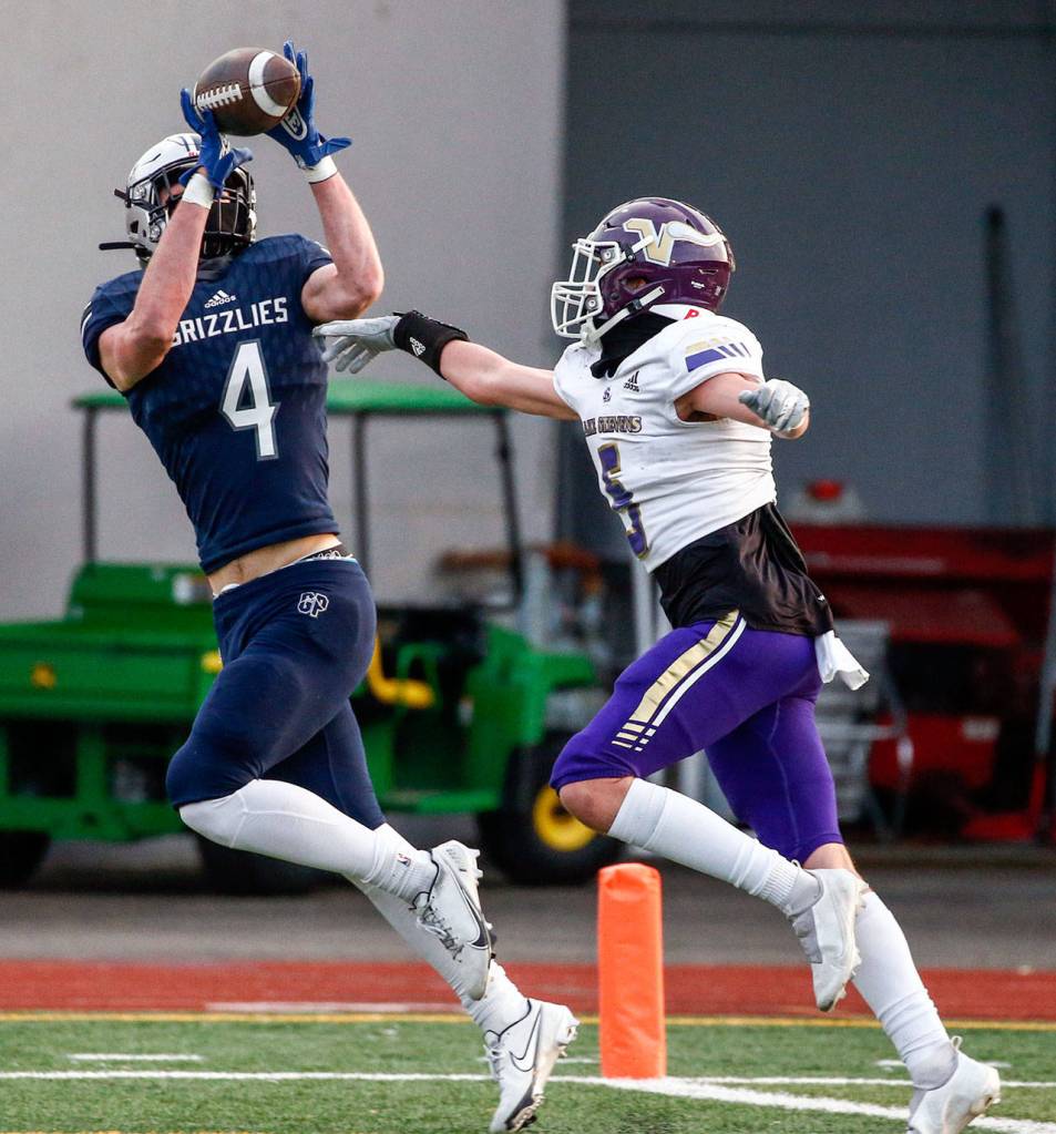 Glacier Peaks Cooper Jensen makes a touchdown reception against Lake Stevens Alexander Davis Thursday night at Veterans Memorial Stadium in Snohomish on April 1, 2021. (Kevin Clark / The Herald)