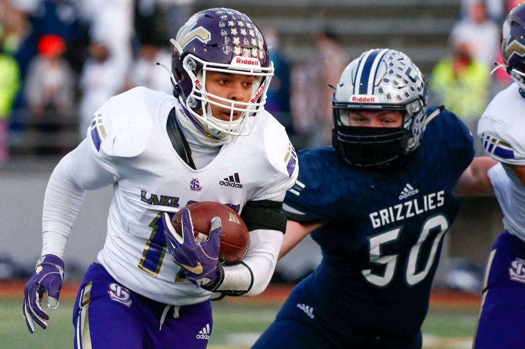 Lake Stevens Jayden Limar rushes with Glacier Peaks Hunter Morrison Thursday night at Veterans Memorial Stadium in Snohomish on April 1, 2021. (Kevin Clark / The Herald)