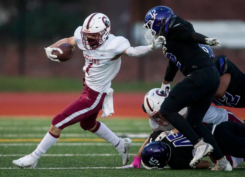 Cascades Michael Purl (left) runs the ball during a game against Kamiak on April 1, 2021, in Everett. (Olivia Vanni / The Herald)