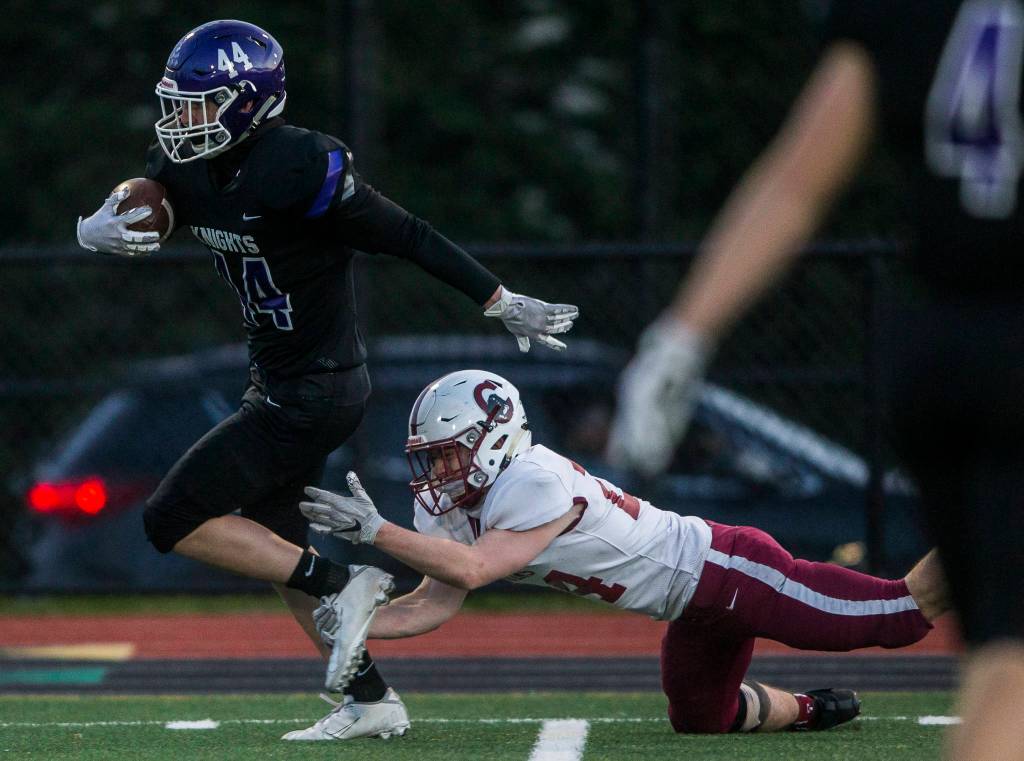 Kamiaks Chance Loudenback (left) escapes a tackle by Cascades Ronan Mckague and runs in for a touchdown during a game on April 1, 2021, in Everett. (Olivia Vanni / The Herald)