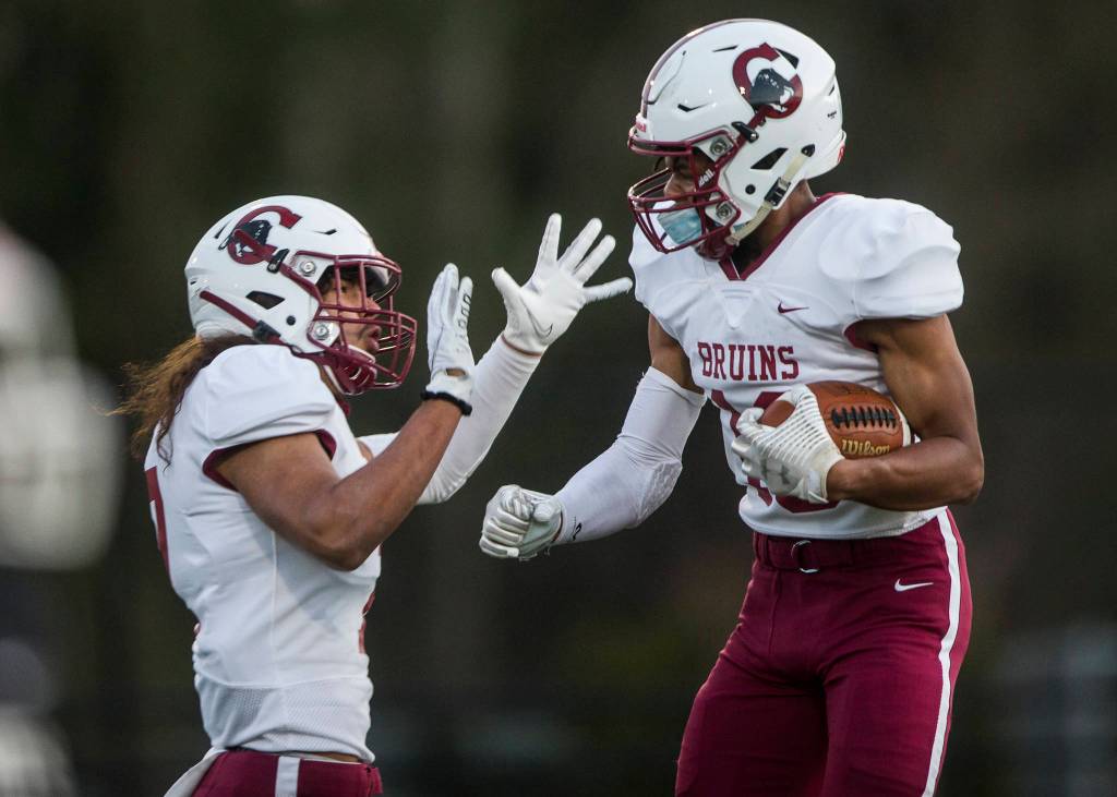 Cascades Amir Andrews (right) celebrates his touchdown during a game against Kamiak on April 1, 2021, in Everett. (Olivia Vanni / The Herald)