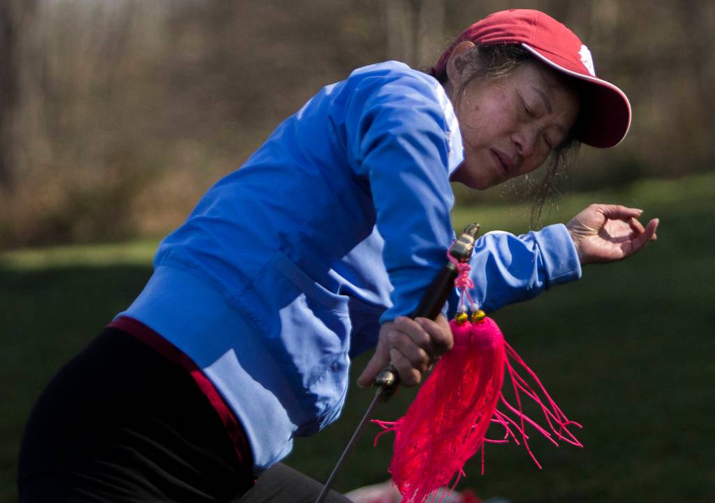 Dongyue Zhuang does advanced tai chi sword movements at Harborview Park on Tuesday in Everett. (Olivia Vanni / The Herald)