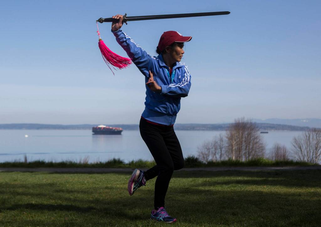 Dongyue Zhuang does advanced tai chi sword movements at Harborview Park on Tuesday in Everett. (Olivia Vanni / The Herald)