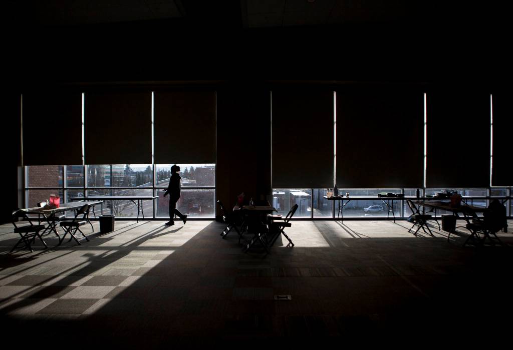 Workers set up the vaccination stations at Angel of the Winds Arena on Tuesday in Everett. (Olivia Vanni / The Herald)