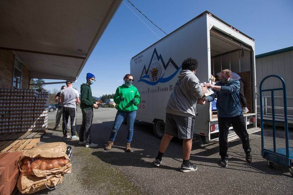 Volunteers and staff unload a truck of food at the new Granite Falls Food Bank on Tuesday. (Andy Bronson / The Herald)