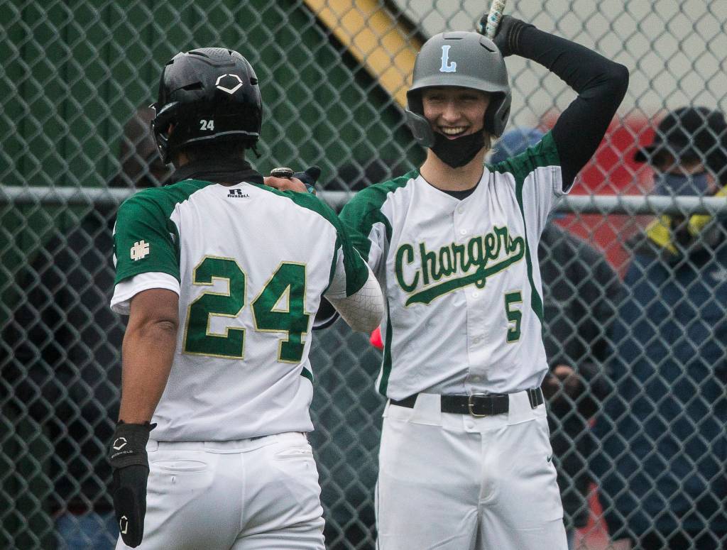 Marysville Getchells Keegan Agen (5) fist bumps Malakhi Knight after scoring during a game against Marysville Pilchuck on April 7, 2021, in Marysville. (Olivia Vanni / The Herald)