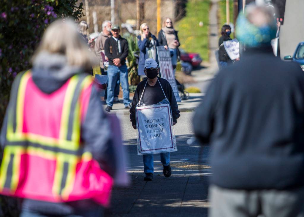 Pro-choice supporters stand on the corner of Hoyt Avenue and 32nd Street across from pro-life supporters on Wednesday in Everett. (Olivia Vanni / The Herald)