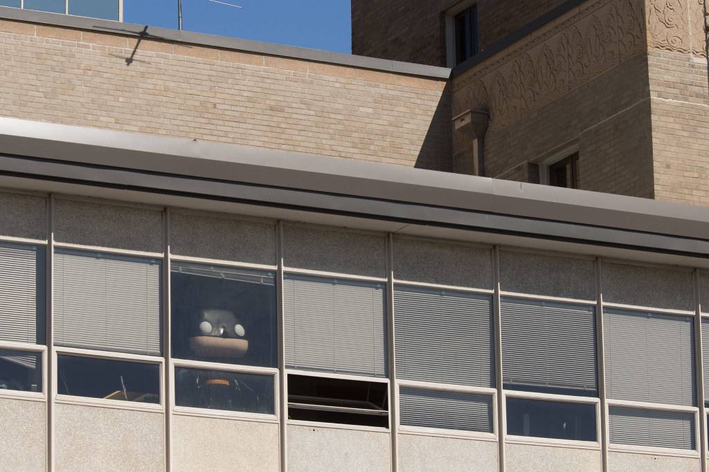 A Funko statue recovered after it was stolen from an Everett comic book store last year peers from a window at the Everett Police Department on Wednesday in Everett. (Andy Bronson / The Herald)