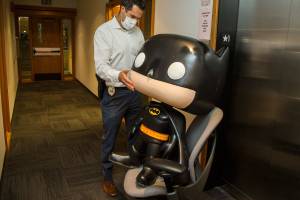 “We are still trying to figure out what to do with him,” said Everett Police Department property crimes Det. Adam Gage, who transports the statue back to a room using a rolling chair on Tuesday, April 13, 2021 in Everett, Washington.The Batman statue was recovered after it was stolen from an Everett comic book store last year.  (Andy Bronson / The Herald)