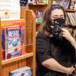 Emily Newman, here with Miranda the cat, bought Main Street Books in Monroe in 2012. (Kevin Clark / The Herald)