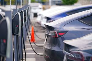 This Aug. 23, 2020 photo shows a long line of unsold 2020 models charge outside a Tesla dealership in Littleton, Colo.  The European Union is lacking sufficient charging infrastructure for electric vehicles, according to the bloc's external auditor. In a report published Tuesday, April 13, 2021, the European Court of Auditors said users are gaining more harmonized access to charging networks but the EU is still “a long way from reaching its Green Deal target of 1 million charging points by 2025." (AP Photo/David Zalubowski)