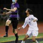 Kamiaks Trace Mohr (left) heads the ball past Meadowdales Tristan Angeles during a game on April 16, 2021, in Mukilteo. (Olivia Vanni / The Herald)