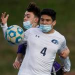 Kamiaks Wyatt Stevens (rear) and Meadowdales Abraham Valle Torres fight for the ball during a game on April 16, 2021, in Mukilteo. (Olivia Vanni / The Herald)