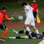 Kamiaks Alexander Hristov (bottom) watches after going down in the goal box as Meadowdale goaltender Avary Olson (0) reaches for the ball during a game on April 16, 2021, in Mukilteo. (Olivia Vanni / The Herald)