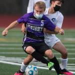 Kamiaks Aidan Drought (front) and Meadowdales Devin Gibson fight for the ball during a game on April 16, 2021, in Mukilteo. (Olivia Vanni / The Herald)