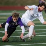 Kamiaks Cade Weatherbie (left) and Meadowdales River Stewart fall while fighting for the ball during a game on April 16, 2021, in Mukilteo. (Olivia Vanni / The Herald)
