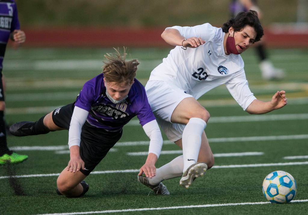 Kamiaks Cade Weatherbie (left) and Meadowdales River Stewart fall while fighting for the ball during a game on April 16, 2021, in Mukilteo. (Olivia Vanni / The Herald)