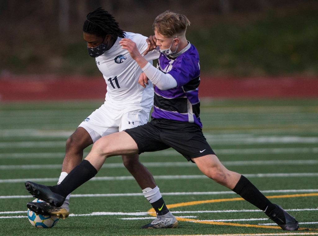 Meadowdales Mark Dormoh (left) steals the ball from Kamiaks Cade Weatherbie during a game on April 16, 2021, in Mukilteo. (Olivia Vanni / The Herald)