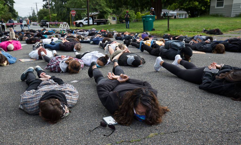 Over 100 people lie on the street during a protest at Lynnwood City Hall on July 7. (Andy Bronson / The Herald)