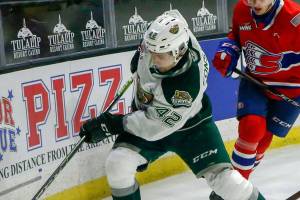 Silvertips' Cole Fonstad races for a rebound with Chiefs' Jordan Chudley and Chiefs' Adam Beckman giving chase Saturday night at Angel of the Winds Arena in Everett on March 20, 2021. (Kevin Clark / The Herald)